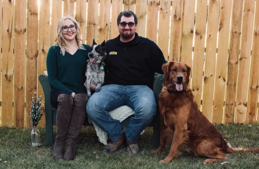 A woman with her partner and two dogs.